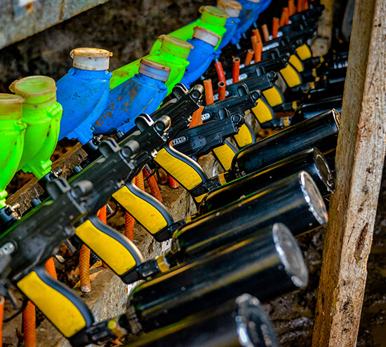 Many paintball guns stacked up neatly