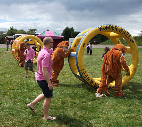 Someone pushing a giant inflatable hamster wheel