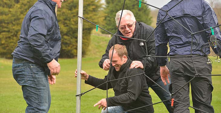 A group laughing after falling in nets