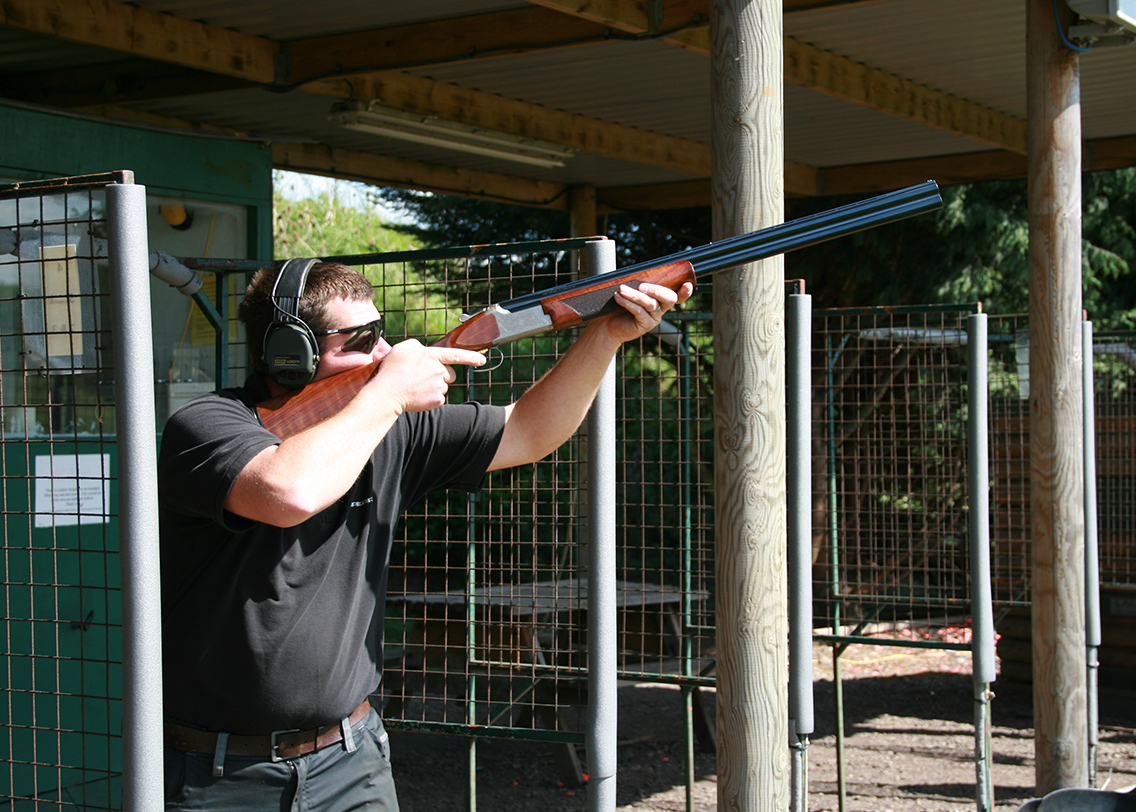 A man showing how to fire a shotgun